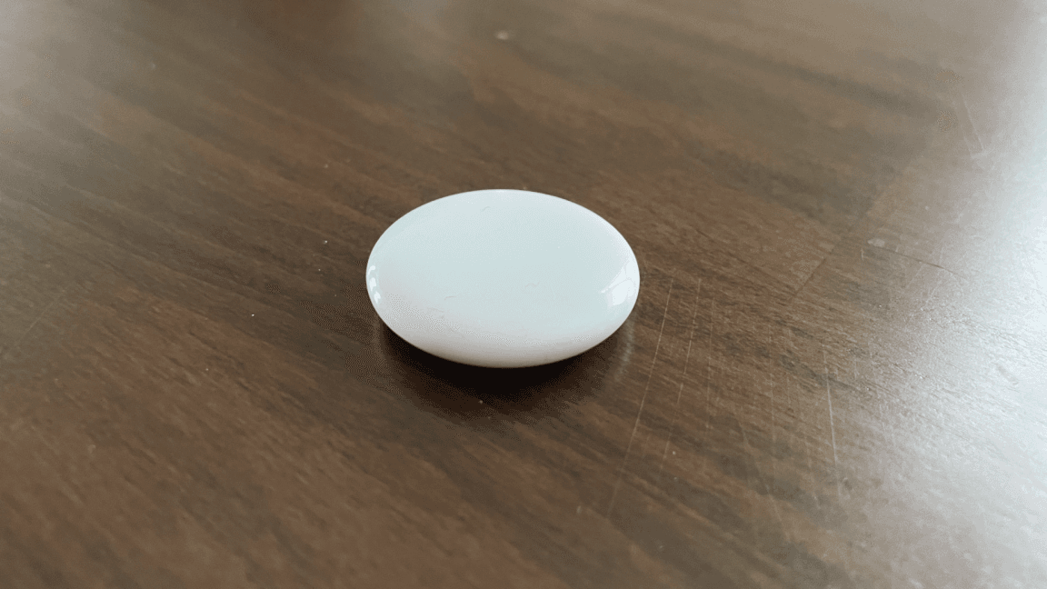 Close-up of an Apple AirTag 2 Bluetooth tracker attached to a keyring