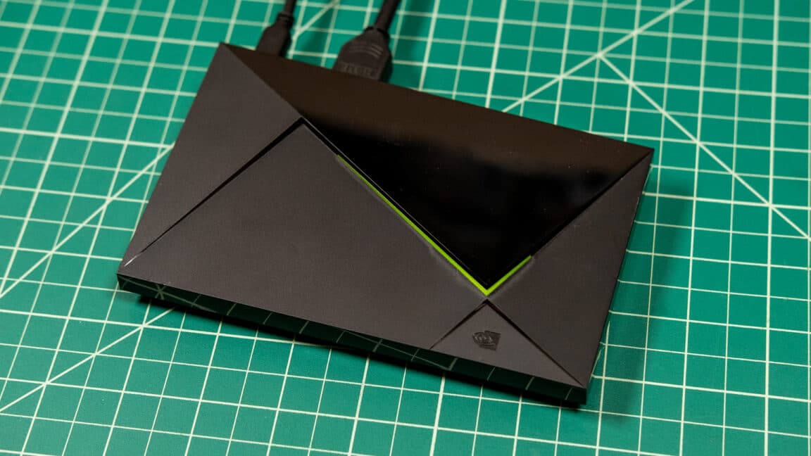 Nvidia Shield TV set-top box and remote control next to a television