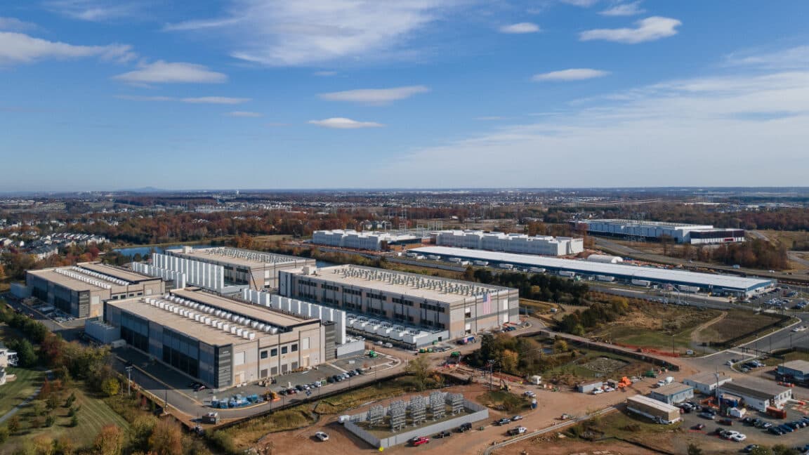 Large data center complex next to natural gas power plant with turbines and exhaust plumes