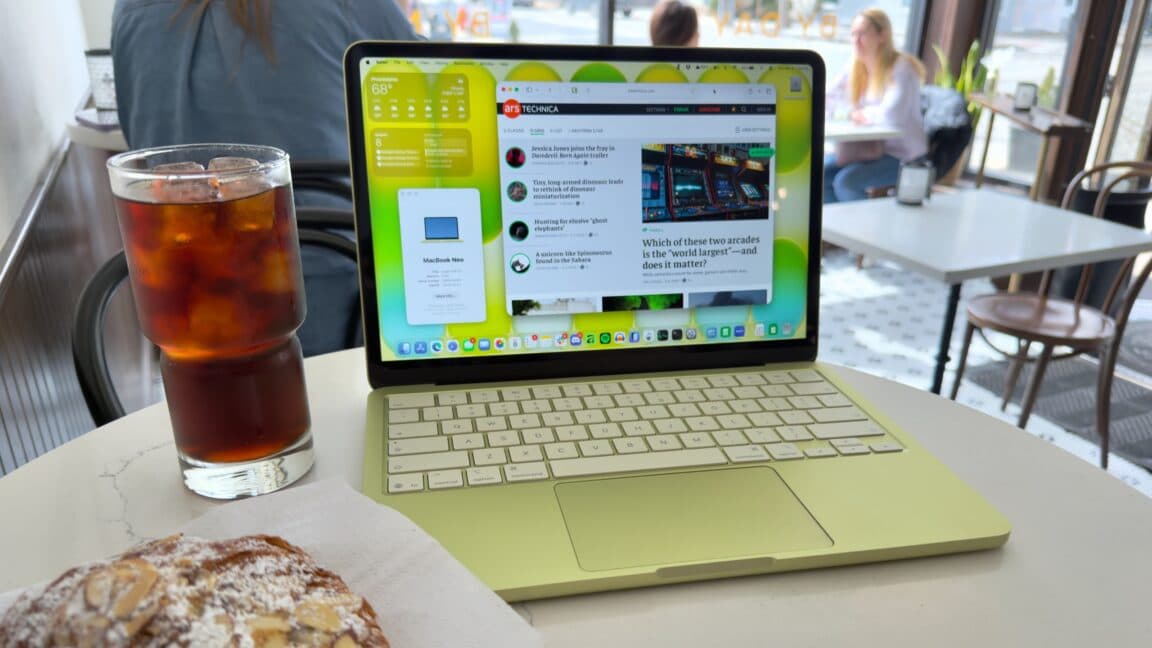 Student working on a colourful Apple MacBook Neo laptop at a café table