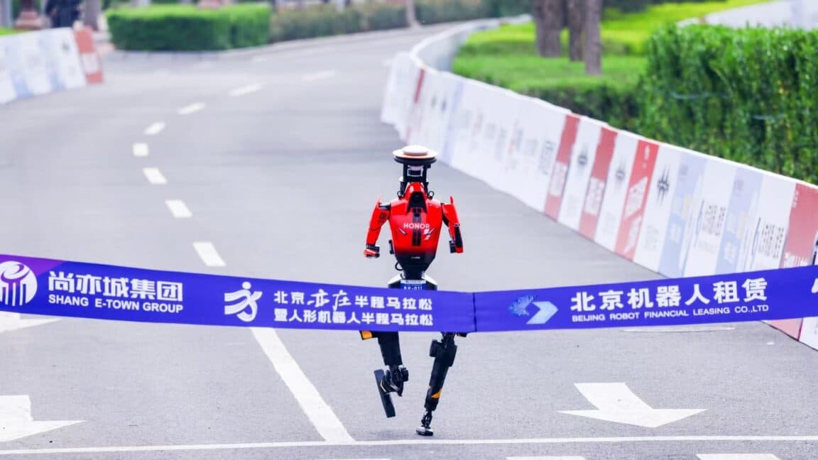Humanoid robot running alongside human athletes during a city half‑marathon race