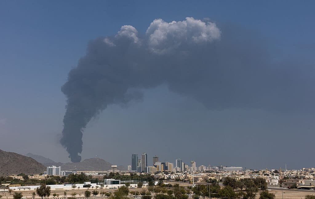 Smoke rising above an industrial area near data center buildings after a drone strike
