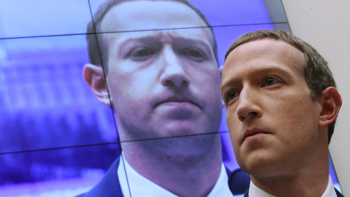 Illustration of Mark Zuckerberg’s digital avatar speaking on screens in a modern office