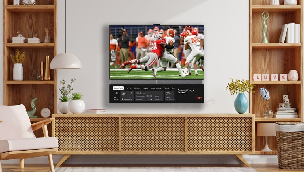 Dual-screen smart TV in a living room with ads displayed on a secondary lower screen