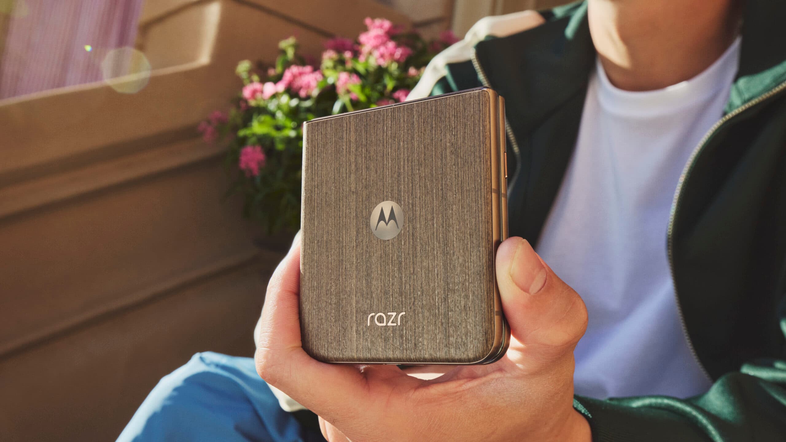 Motorola Razr Fold and Razr flip phones displayed half-open on a table, showing their folding screens and stylish backs